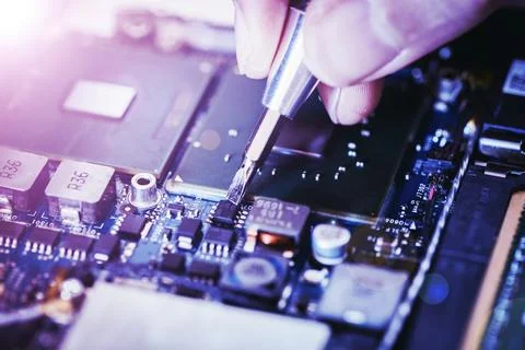 Computer circuit board, hand and screwdriver: Technician is fixing a motherboard Foto stock