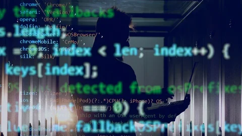 Computer code is emerging above the technician operating the laptop Stock Footage 114739800