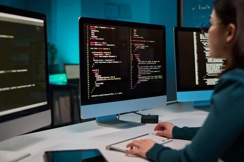 Computer with Code Lines on Screen and Girl Typing Stock Photos