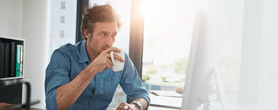 Computer, coffee and reading with designer man at desk in office for development Stock Photos