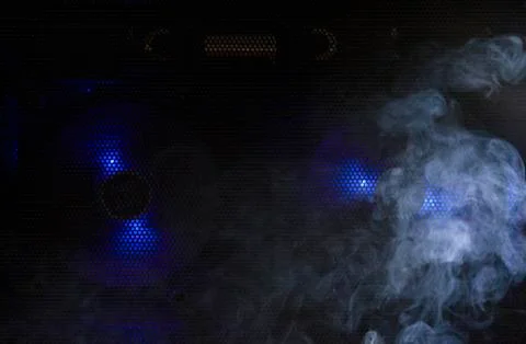 Computer cooling fan with blue light and smoke The dangerous concept of using Stock Photos