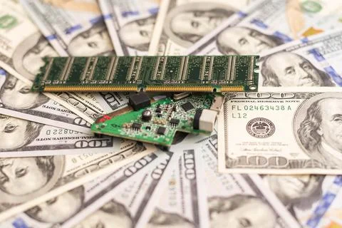 Computer CPU and memory chips on US dollar banknotes background. The high cost Stock Photos