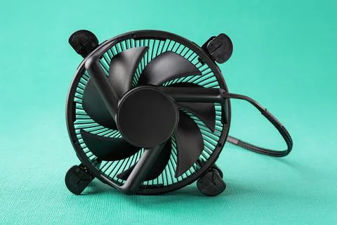Computer CPU cooling fan radiator on its side over a turquoise background. Stock Photos