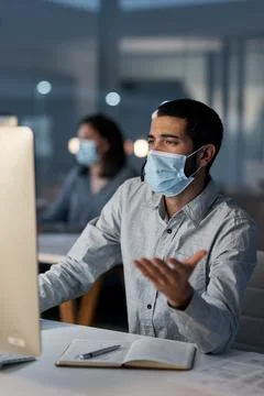 Computer, design and face mask with business man in coworking office at nig.. Stock Photos