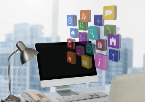 Computer on desk with apps against city window Stock Photos