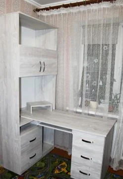 Computer Desk made of chipboard. Workplace in the interior of the room. Stock Photos