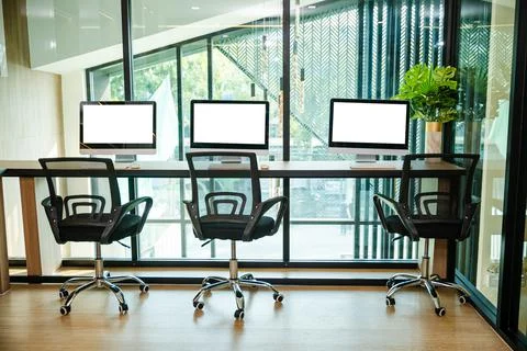 Computer desktop blank screen in front of window in office Stock Photos