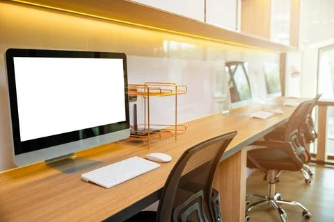 Computer desktop blank screen in front of window in office Stock Photos