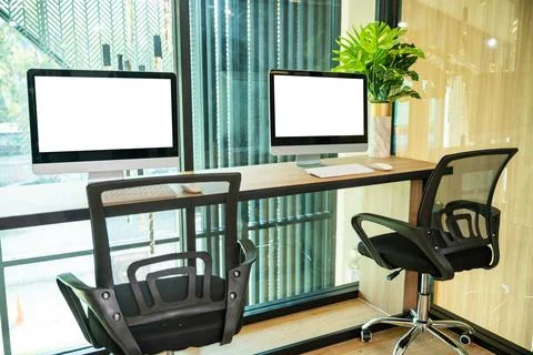 Computer desktop blank screen in front of window in office Stock Photos