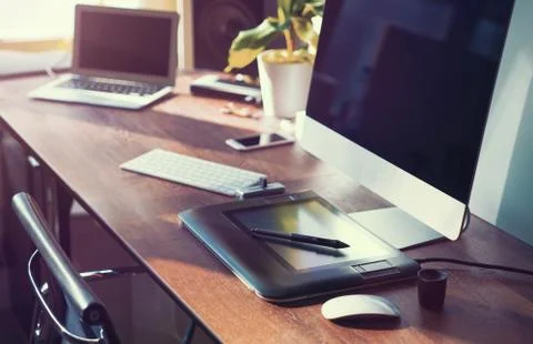 Computer on desktop in hipster workplace office - no people Stock Photos