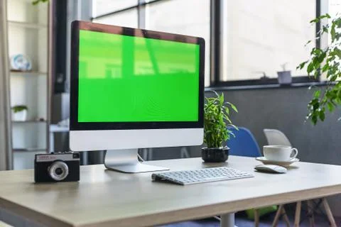 Computer desktop with mock-up green screen white background in office and Lov Stock Photos