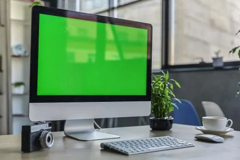 Computer desktop with mock-up green screen white background in office and Lov Stock Photos