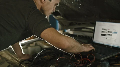 Computer diagnostics in car service: mechanic repairs the damage using the pc Vídeos de archivo 64860337