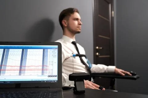 Computer with diagrams for pulse indicating on lie test Stock Photos