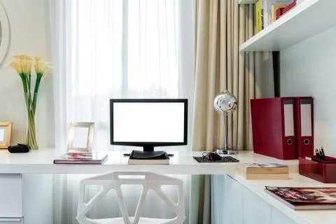 Computer display and office tools on desk in home. Desktop computer screen is Stock Photos