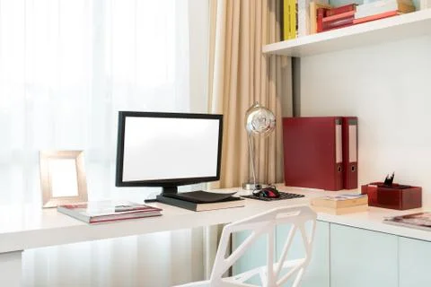 Computer display and office tools on desk in home. Desktop computer screen is Stock Photos