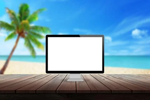 Computer display on desk with beach palm tree and sea in the background mock up  Stock Photos