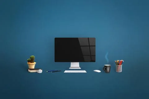 Computer display surrounded by office supplies on blue background. Clean scre Stock Photos