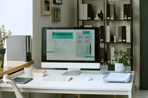 Computer Displaying Business Swot Analysis on Desk in Modern Office Stockfoto's