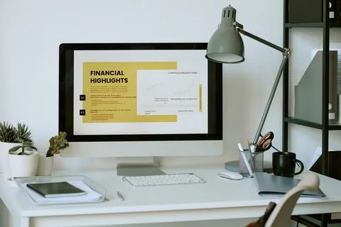 Computer Displaying Financial Presentation on Desk in Office Stockfoto's