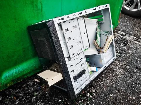 Computer dumping waste - old pc abandoned on wet road background Stock Photos