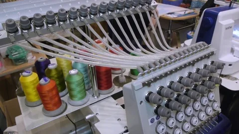 Computer embroidery machine makes bright patterns on a blue background Видео 83376407