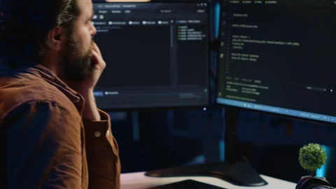 Computer engineer deliberating ways of fixing errors while developing code Stock Footage 265509576