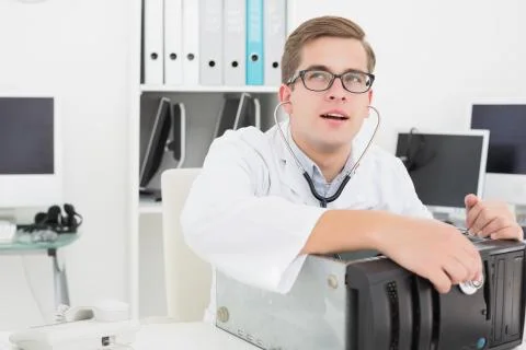 Computer engineer listening to console with stethoscope Stock Photos