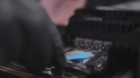 A computer engineer places thermal grease on a central processor of PC Stock Footage 234048684