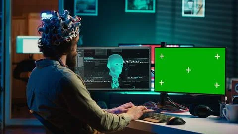 Computer engineer starting mind upload process using green screen PC Stock Photos