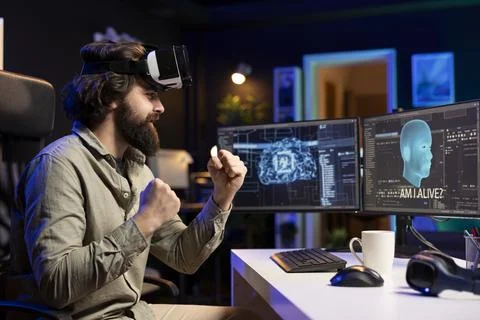 Computer engineer using VR headset, celebrating after awakening sentient AI Stock Photos