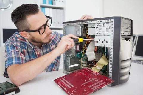 Computer engineer working on broken console with screwdriver Stock Photos