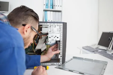 Computer engineer working on broken console with screwdriver Stock Photos