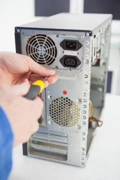 Computer engineer working on broken console with screwdriver Stock Photos
