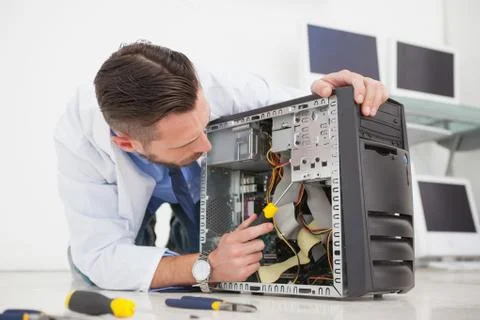Computer engineer working on broken console with screwdriver Stock Photos