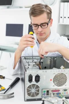 Computer engineer working on broken device with screwdriver Stock Photos