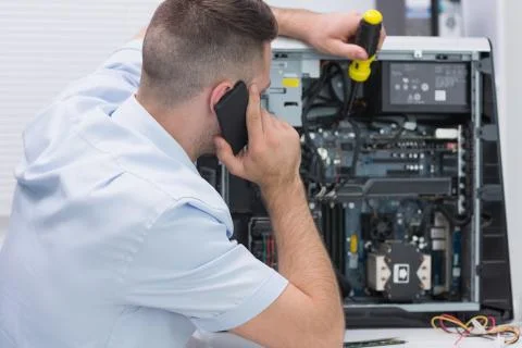 Computer engineer working on cpu while on call Foto stock