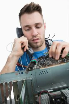Computer engineer working on sound card on cpu while on call Stock Photos
