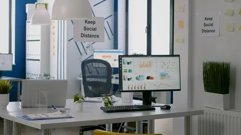 Computer with financial data in modern office interior with keep social distance Stock Photos