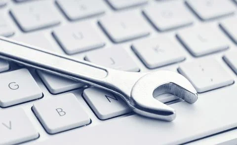 Computer fixing, service or maintenance concept background. Wrench on computer Stock Photos