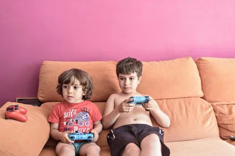 Computer game competition. Gaming concept. Excited children leaning on the sofa Stock Photos