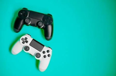 Computer game competition. Gaming concept. White and black joysticks on green Fotos Stock