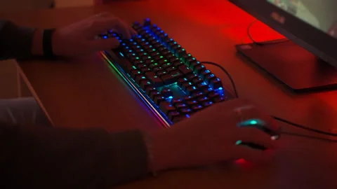 Computer gamer sitting at the table in front of powerful PC and playing cyber Stock-Footage 142174988