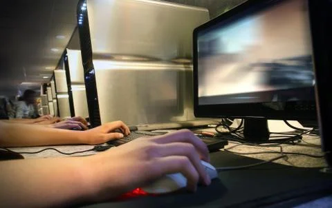 Computer gaming at internet cafe Stock Photos
