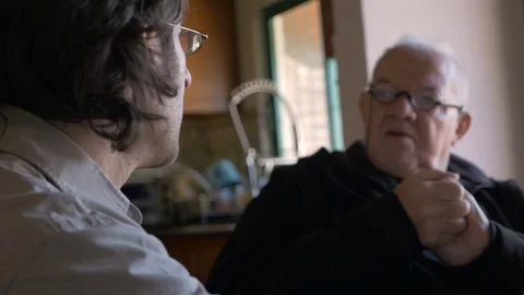 A computer geek explains how to do something on a laptop to an elderly man Stock Footage 71722508