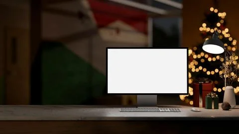 A computer, gift boxes and a table lamp on a tabletop in a dark room on the.. Stock Photos