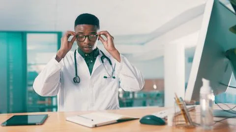Computer, glasses and notebook with doctor black man at desk in hospital fo.. Stock Photos