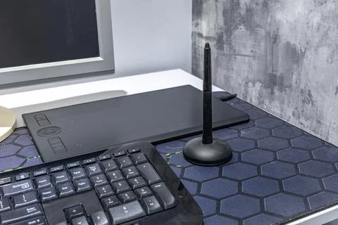 A computer graphics desk, a wireless mouse and a pen for drawing on the des.. Stock Photos