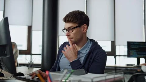 Computer guy looking screen on office. Thoughtful engineer checking code problem Stock-Fotos