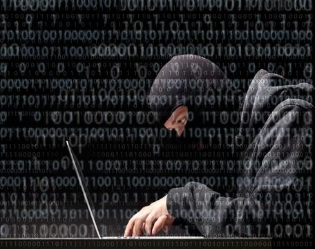Computer hacker in a balaclava Computer hacker in a balaclava working in t... Stock Photos